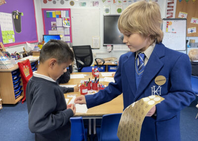 JD pupil hands out stickers in a classroom.