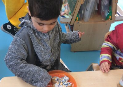 A Nursery pupil eats a gingerbread man.