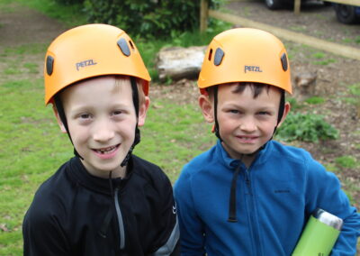Two Year 3 pupils stand with helmets on at PGL.