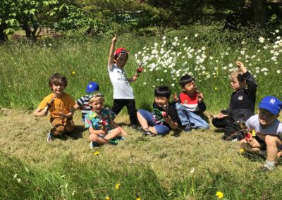 Year 1 pupils sit in the grass on their school trip.
